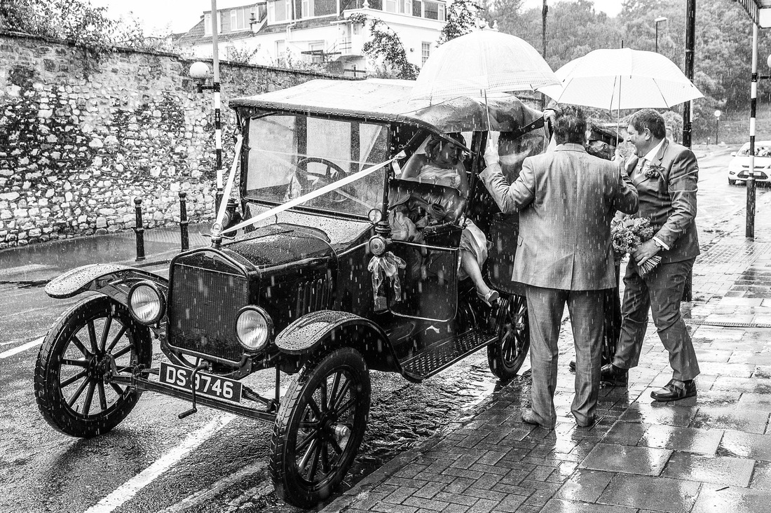 Bride arriving at a very wet wedding